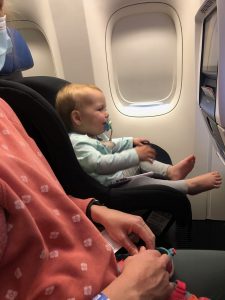 my daughter in car seat on an airplane in the window seat