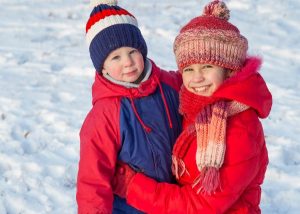 kids in winter clothing to keep warm ice fishing